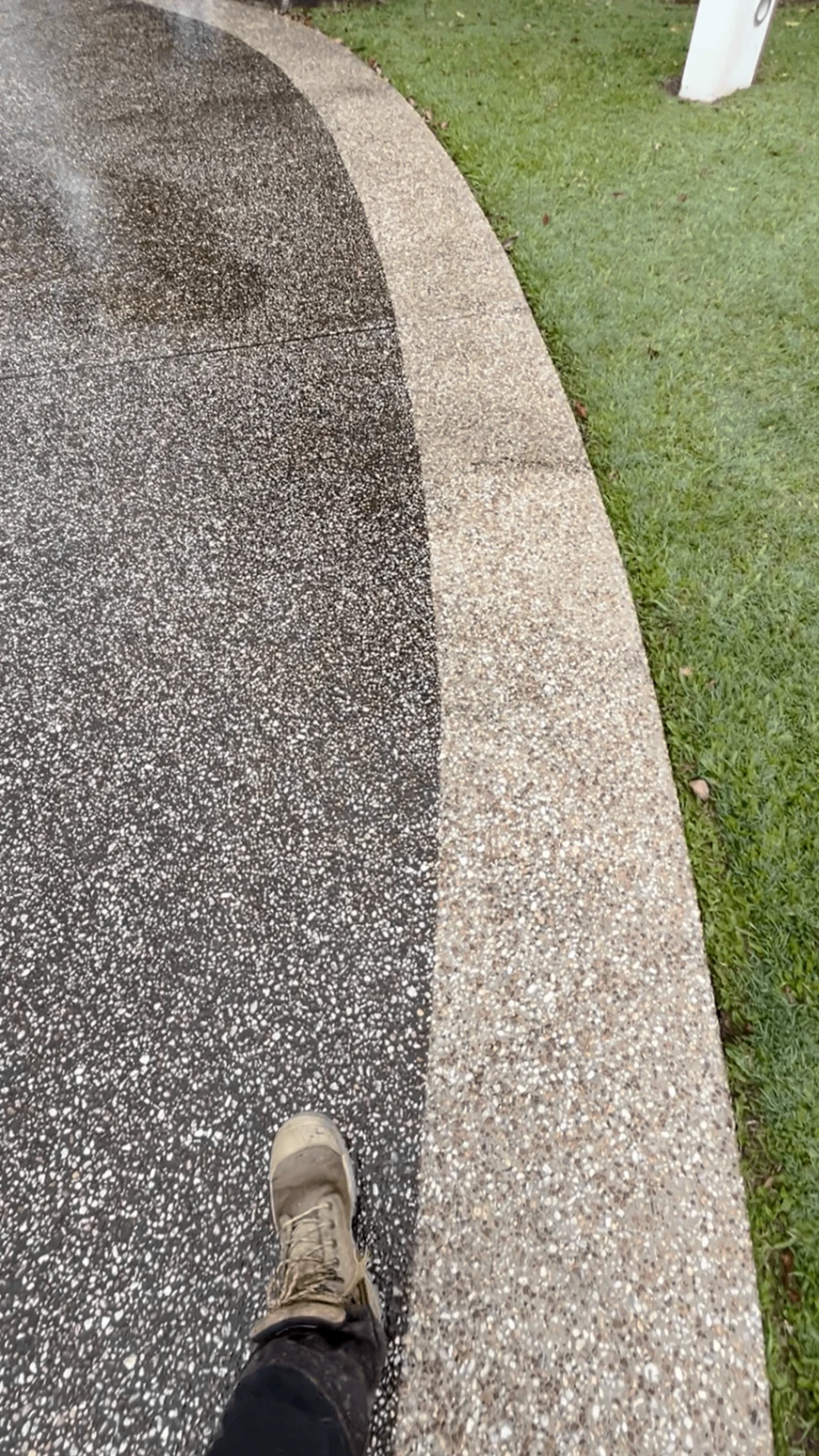 Exposed aggregate driveway half cleaned, showing the before and after